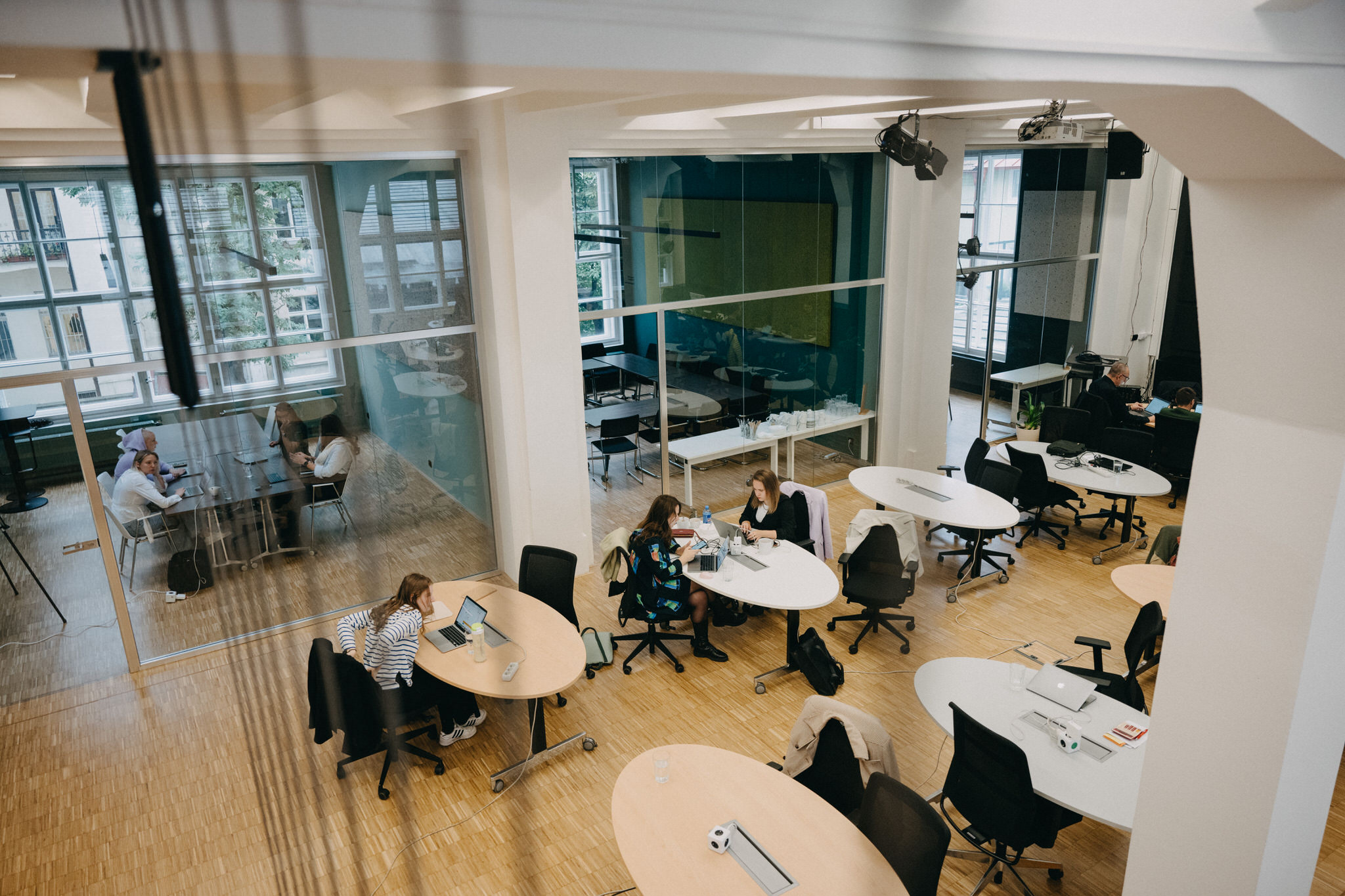 Impact Hub Praha – pohled na sdílené pracovní stoly